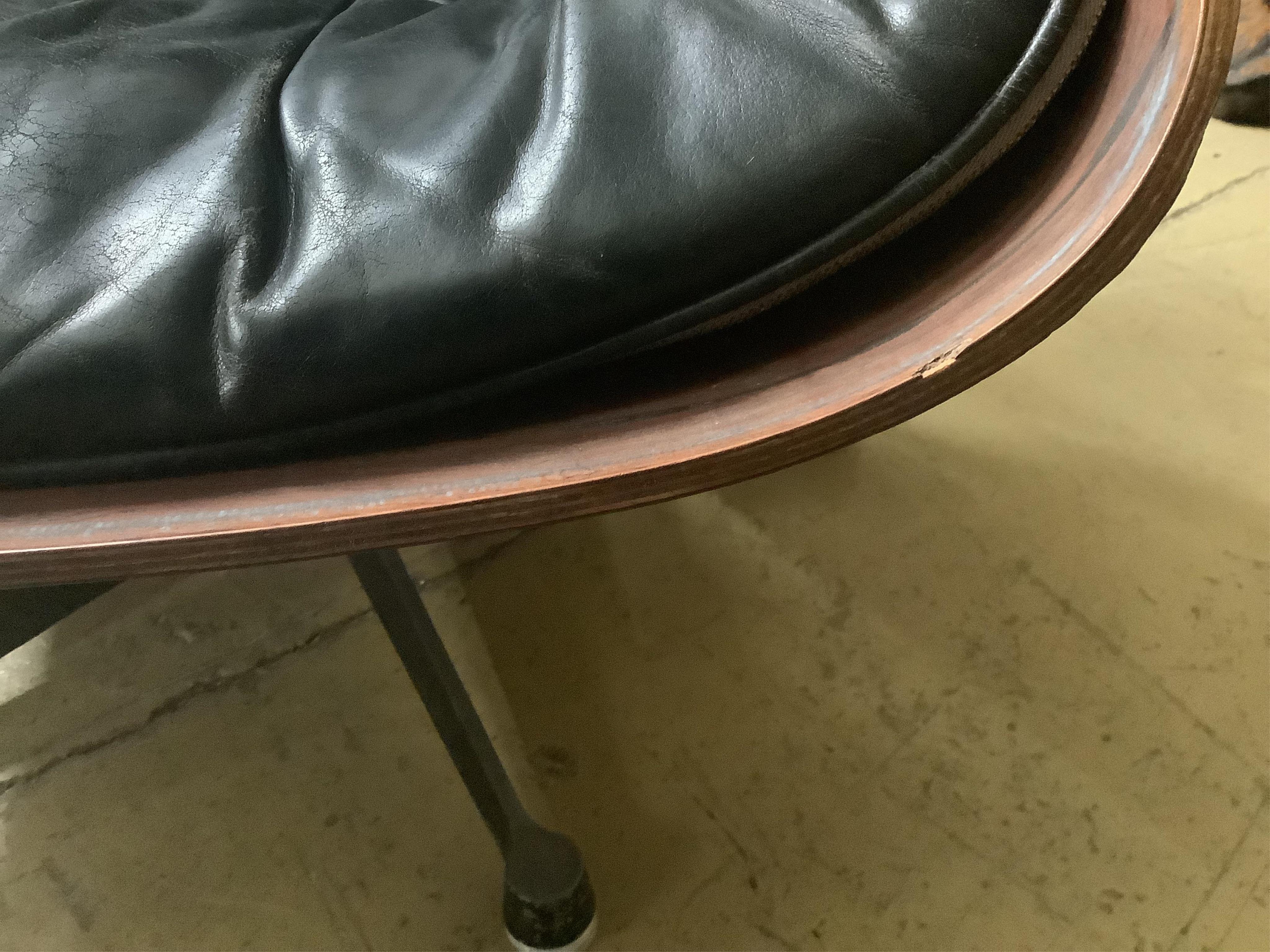 Charles and Ray Eames for Herman Miller Interform, an Indian rosewood and black leather lounge chair and ottoman, circa 1960, chair width 85cm, depth 68cm, height 81cm. Condition - poor to fair